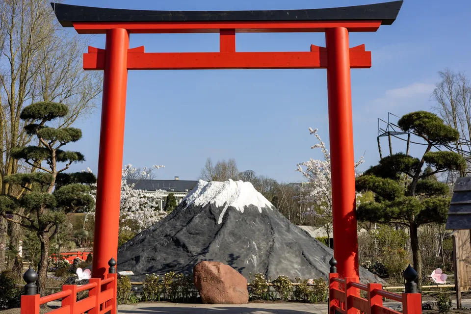 A red torii gate frames a replica of Mount Fuji, in the Islands of the Rising Sun.