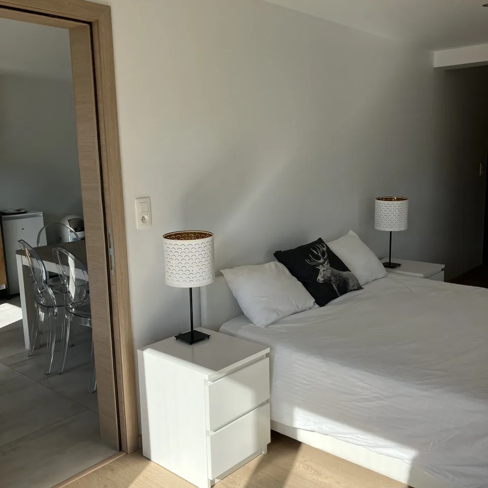 The south bedroom of Pegasus I: a white double bed between two bedside lamps.